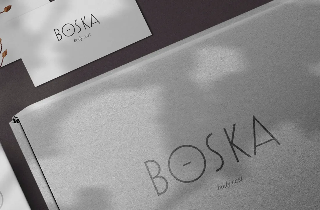 a set of printed branding materials for BOSKA brand including off-white boxes and business card