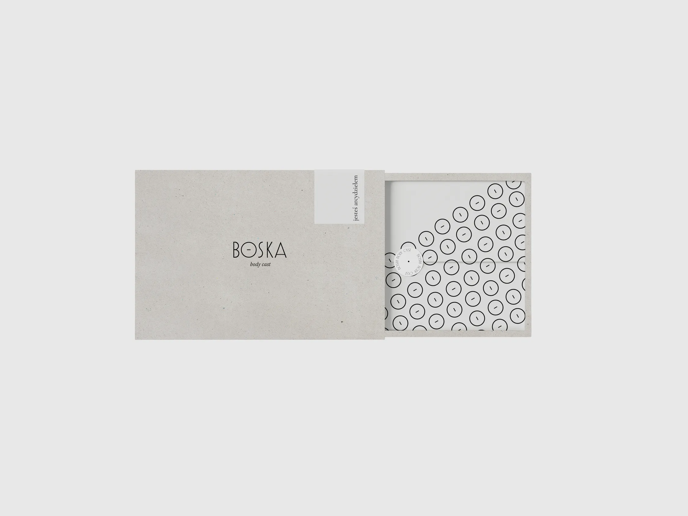 a box with BOSKA logo on top, inside there's paper with design made out of the brand's symbol, Greek letter theta