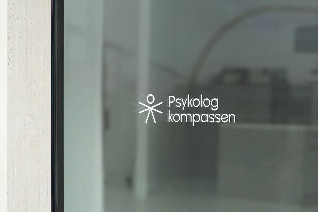 Psykologkompassen logo presented as a sticker on a window glass