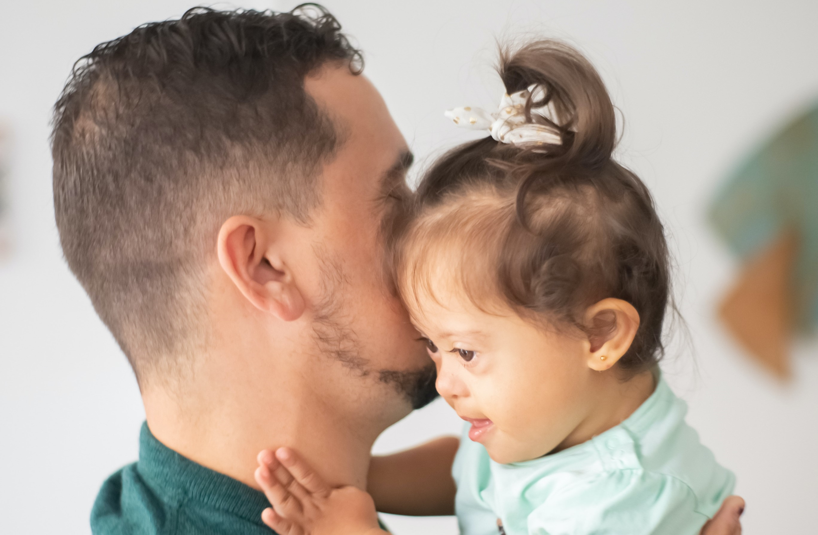 a photograph of a parent holding a baby with Down's Syndrome